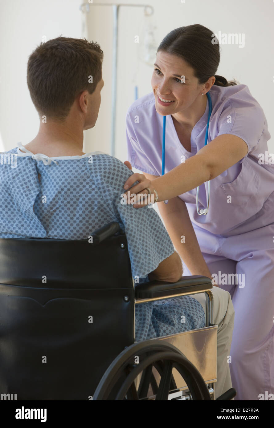 Female nurse with hand on patient’s shoulder Stock Photo