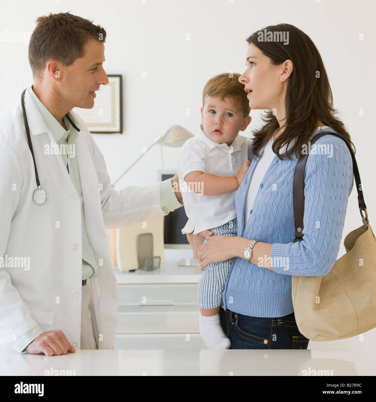 Male doctor talking to mother and son Stock Photo - Alamy
