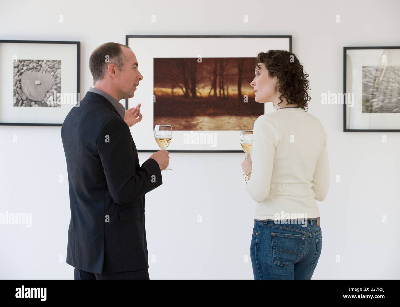 Couple discussing art at art gallery Stock Photo