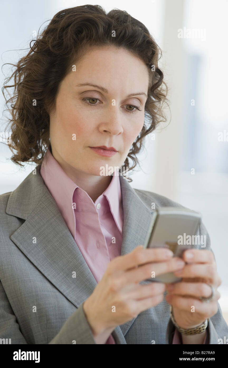 Businesswoman looking at electronic organizer Stock Photo