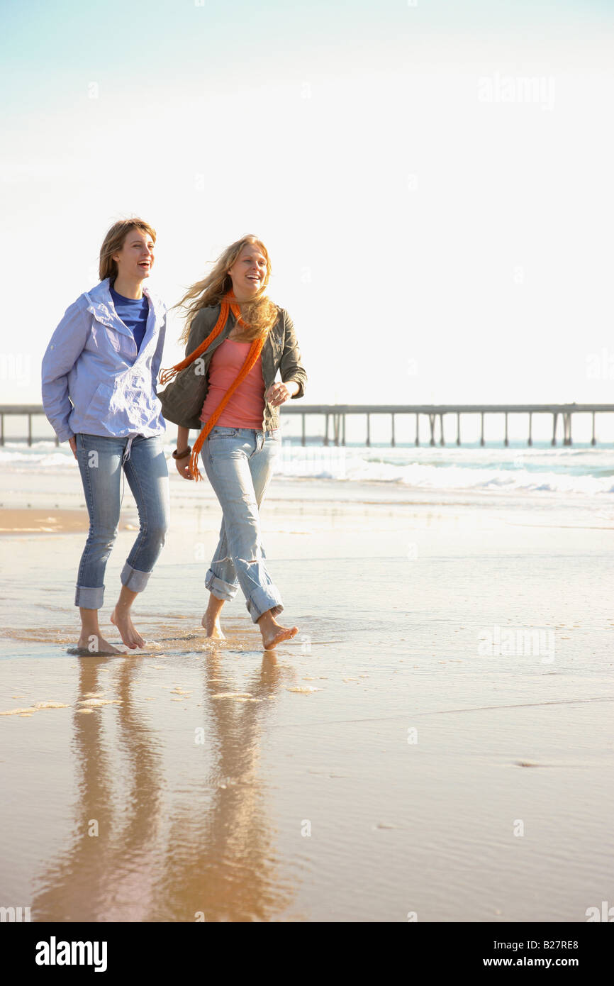 Two women walking on beach Stock Photo - Alamy