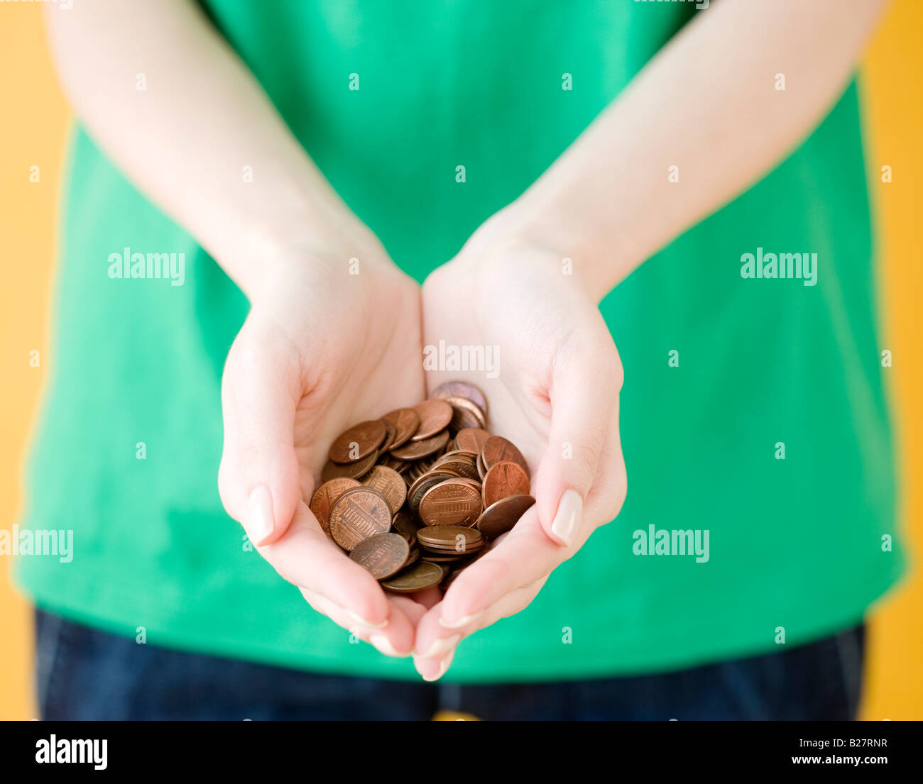 Woman holding handful of pennies Stock Photo