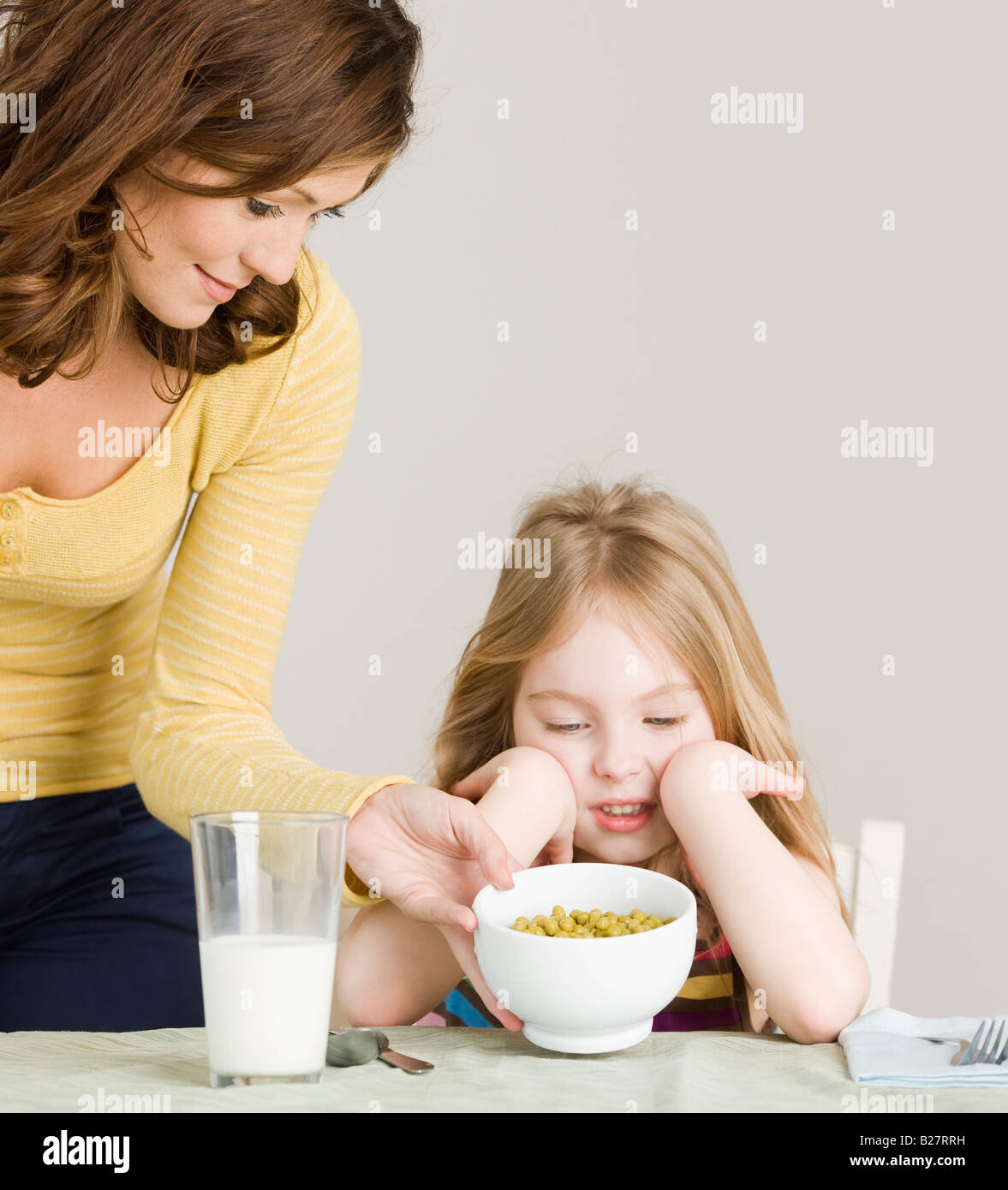 Mother serving vegetables to daughter Stock Photo