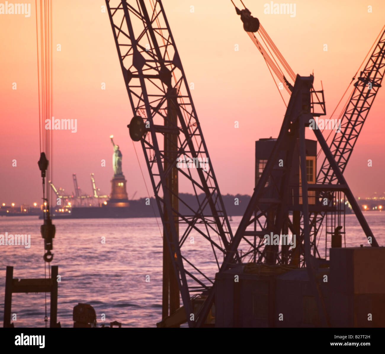 Crane with Statue of Liberty in background, New York, United States Stock Photo