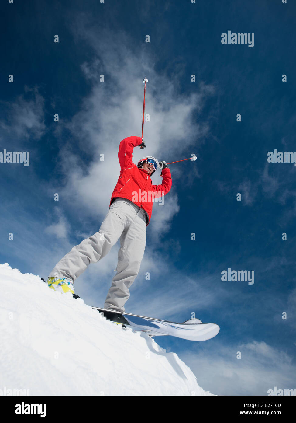 Man on skis with arms raised Stock Photo - Alamy
