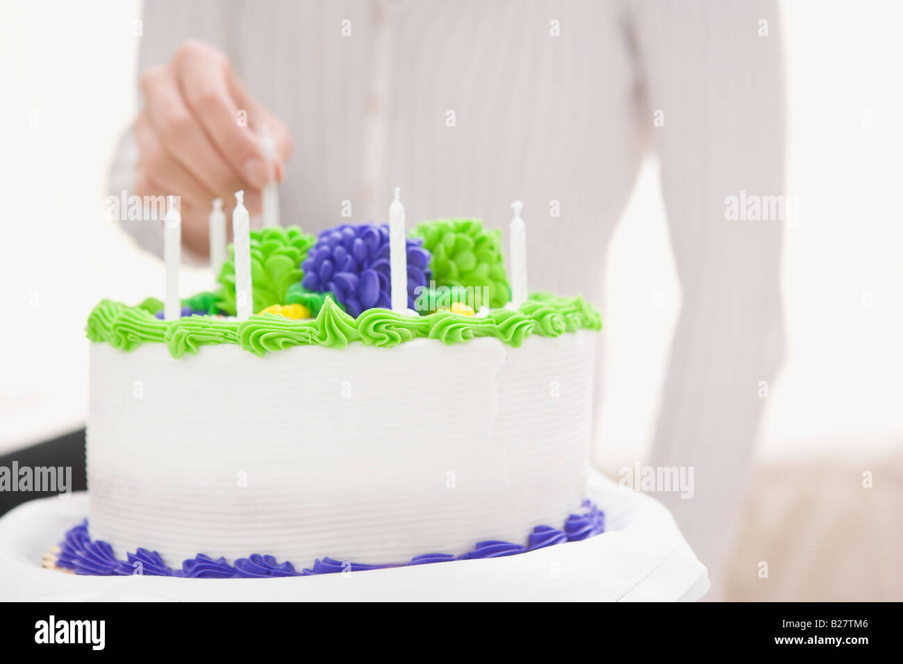 Woman putting candle on birthday cake Stock Photo Alamy