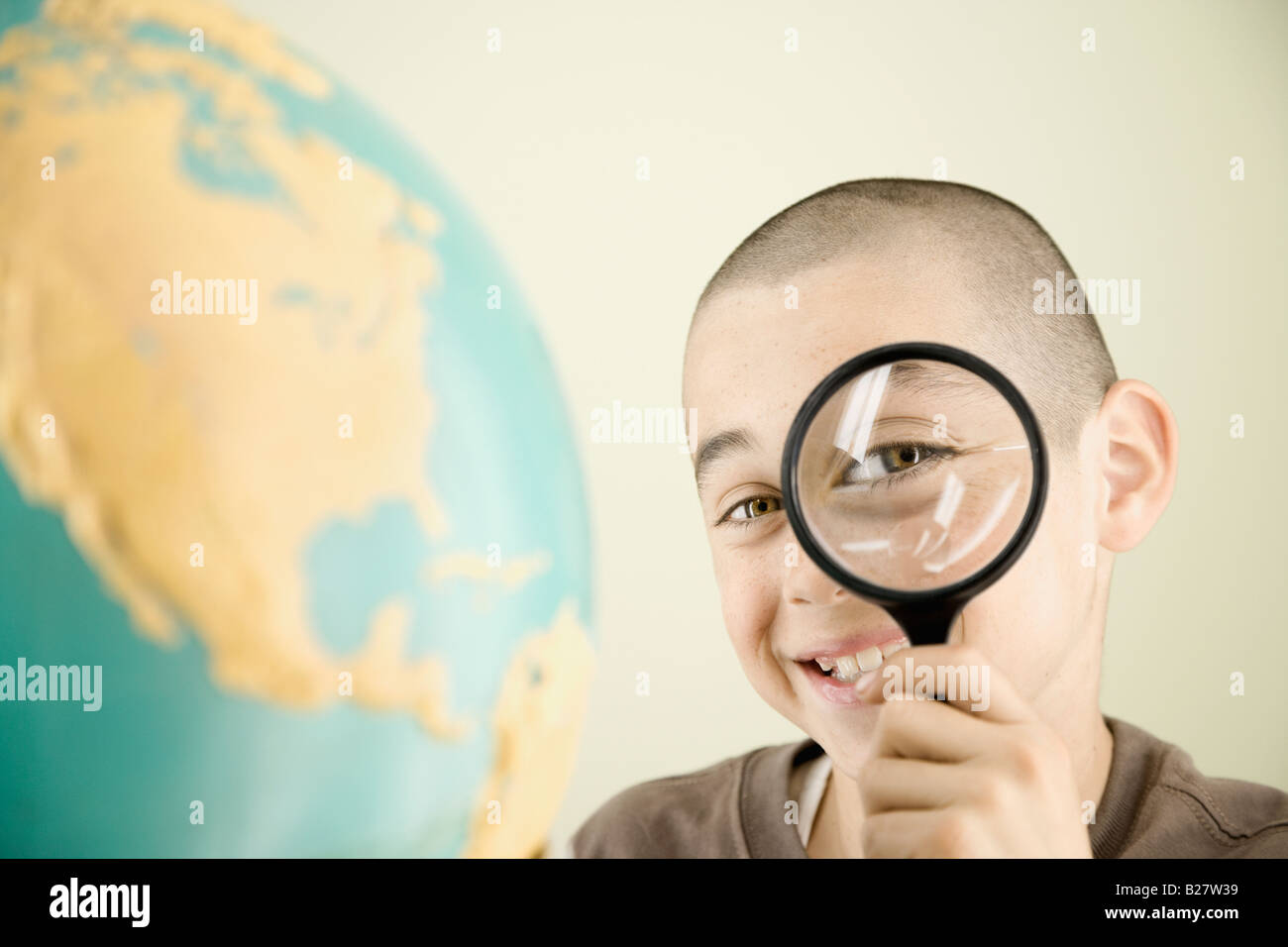 Boy looking through magnifying glass Stock Photo