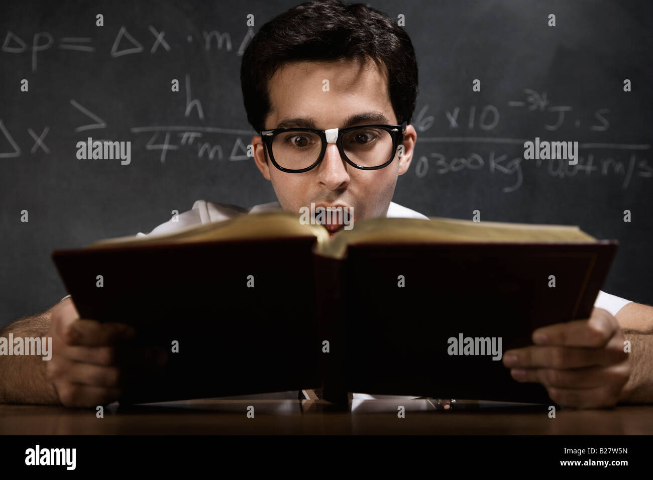 Nerdy man reading book Stock Photo Alamy