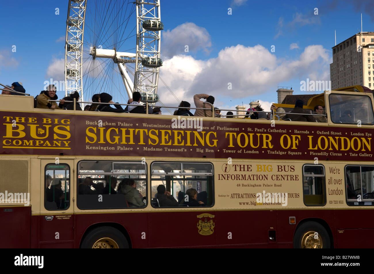Tourists exploring London on a double decker bus driving across Westminster bridge with London Eye in the background. Stock Photo