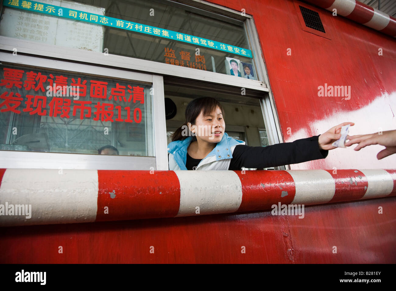 Woman in toll booth collecting payments Guilin China Stock Photo