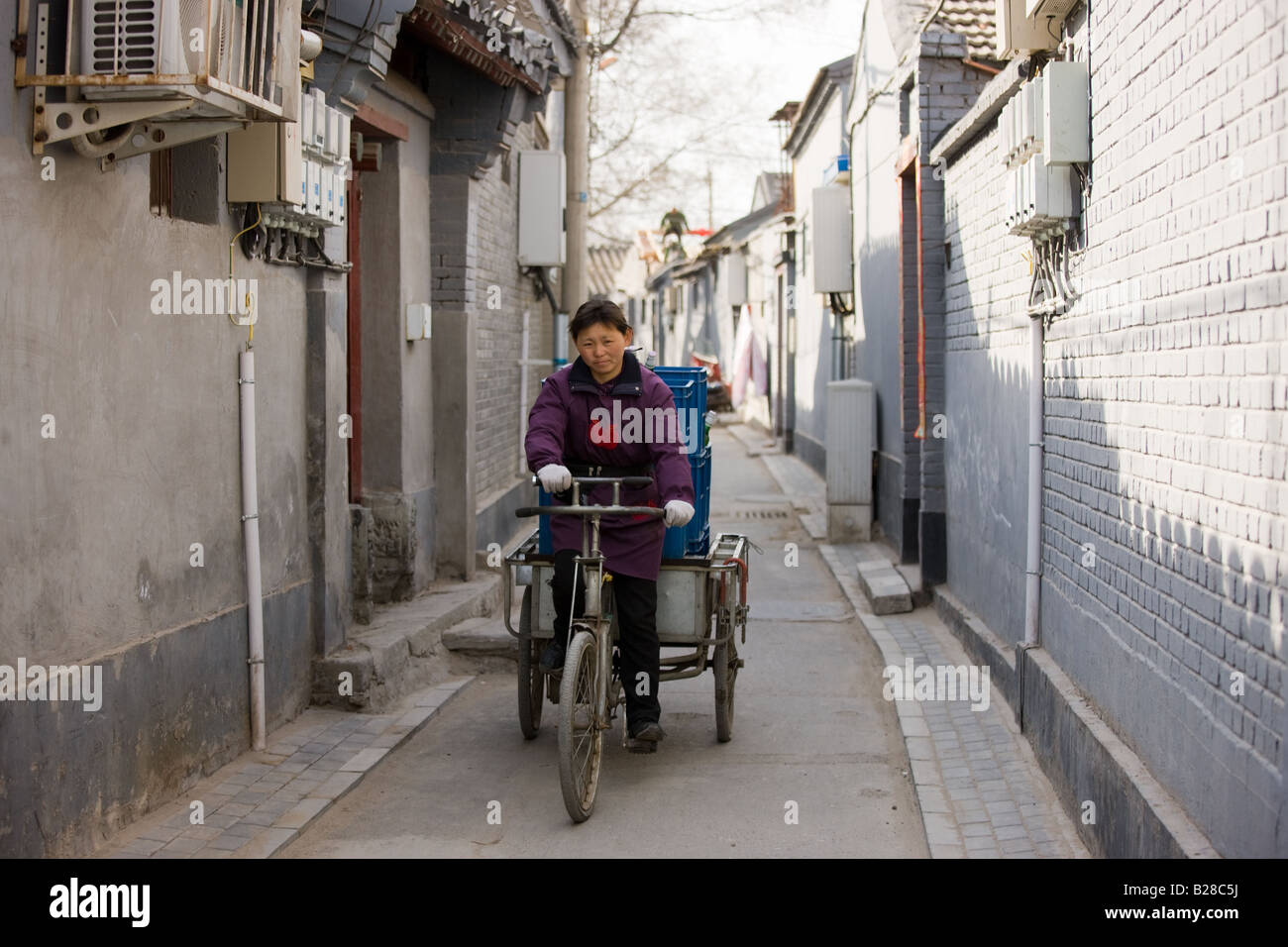 Woman delivering bottled beers on a tricycle cart Hutongs area Beijing China Stock Photo