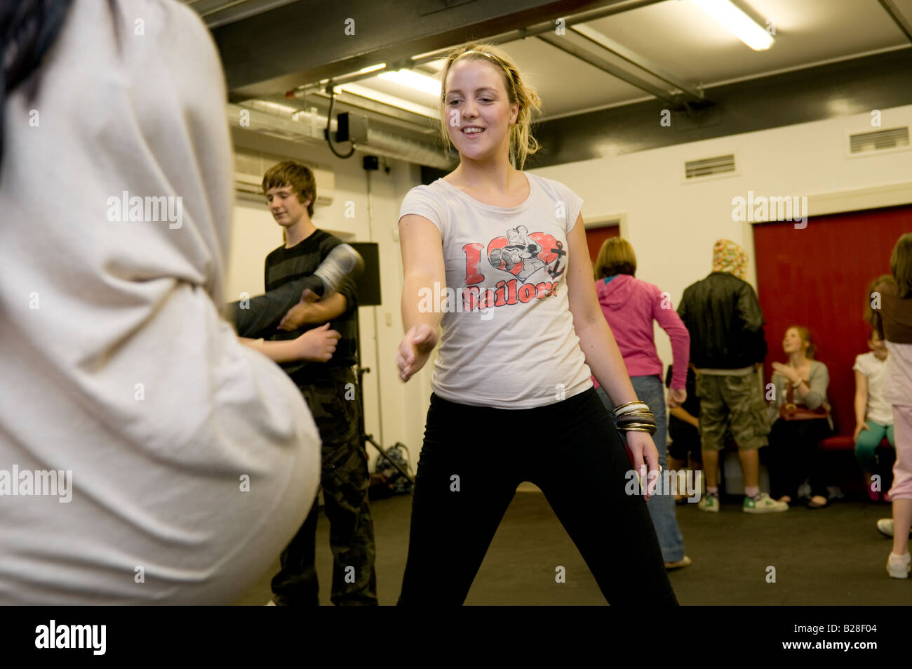 Smiling blonde teenage girl wearing leggings in a dance workshop
