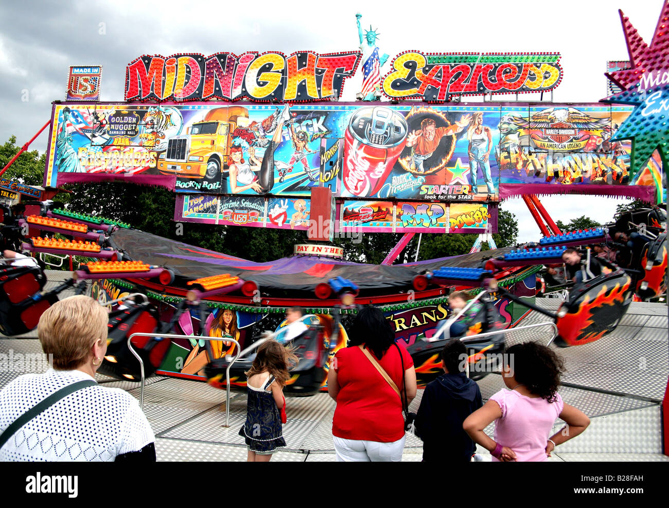Women and childen watching funfair ride in London park Stock Photo Alamy