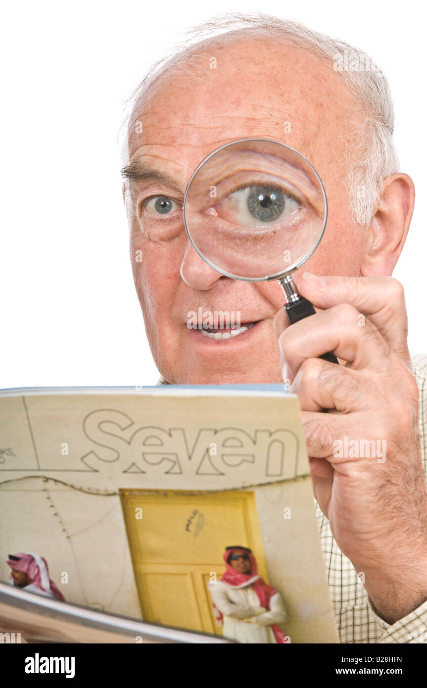 A comical image of an elderly man with a magnifying glass to enlarge one eye against a pure white (255) background. Stock Photo