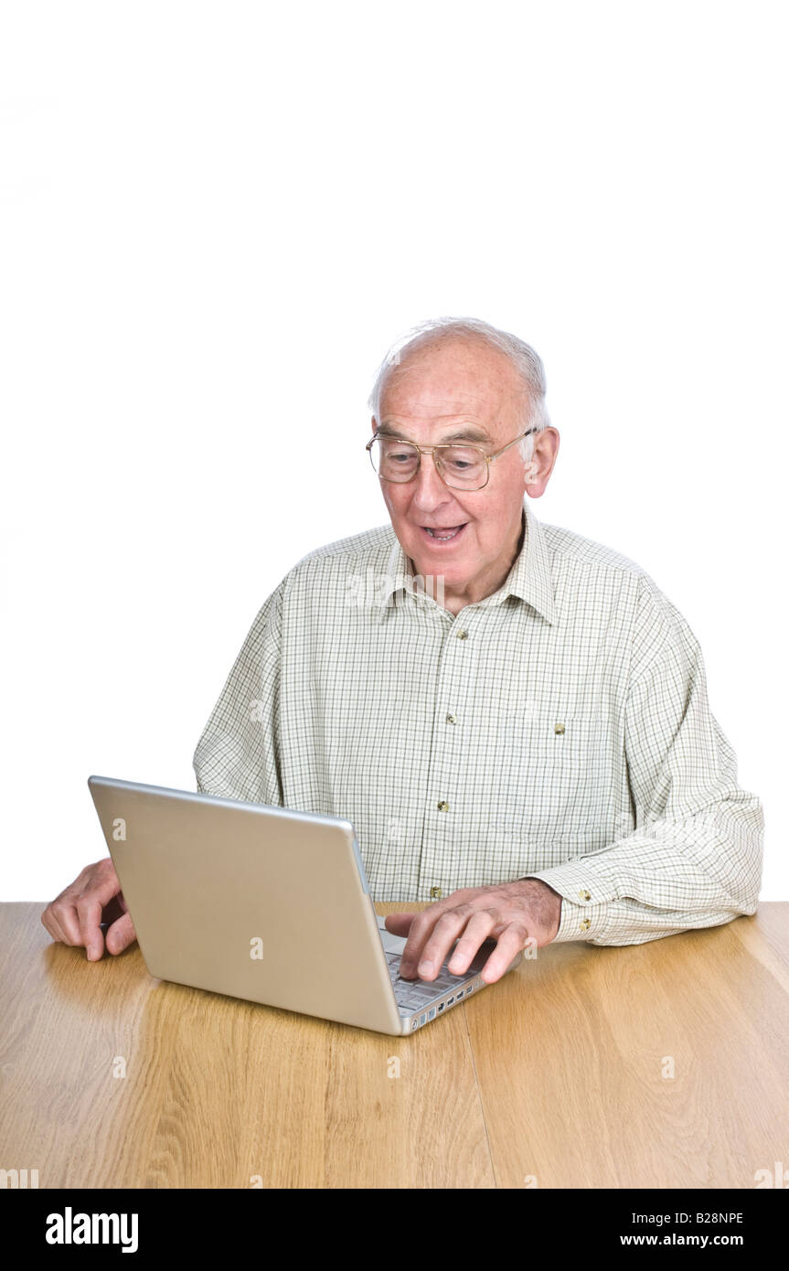 An elderly man at a desk looking at a lap top computer screen with surprise against a pure white (255) background. Stock Photo