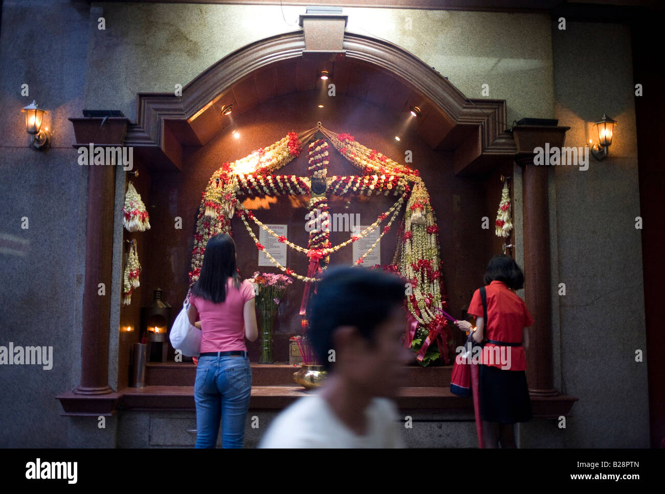 Filipinos stop for prayer at a Catholic shrine in the China Town district of Manila, Philippines. Stock Photo