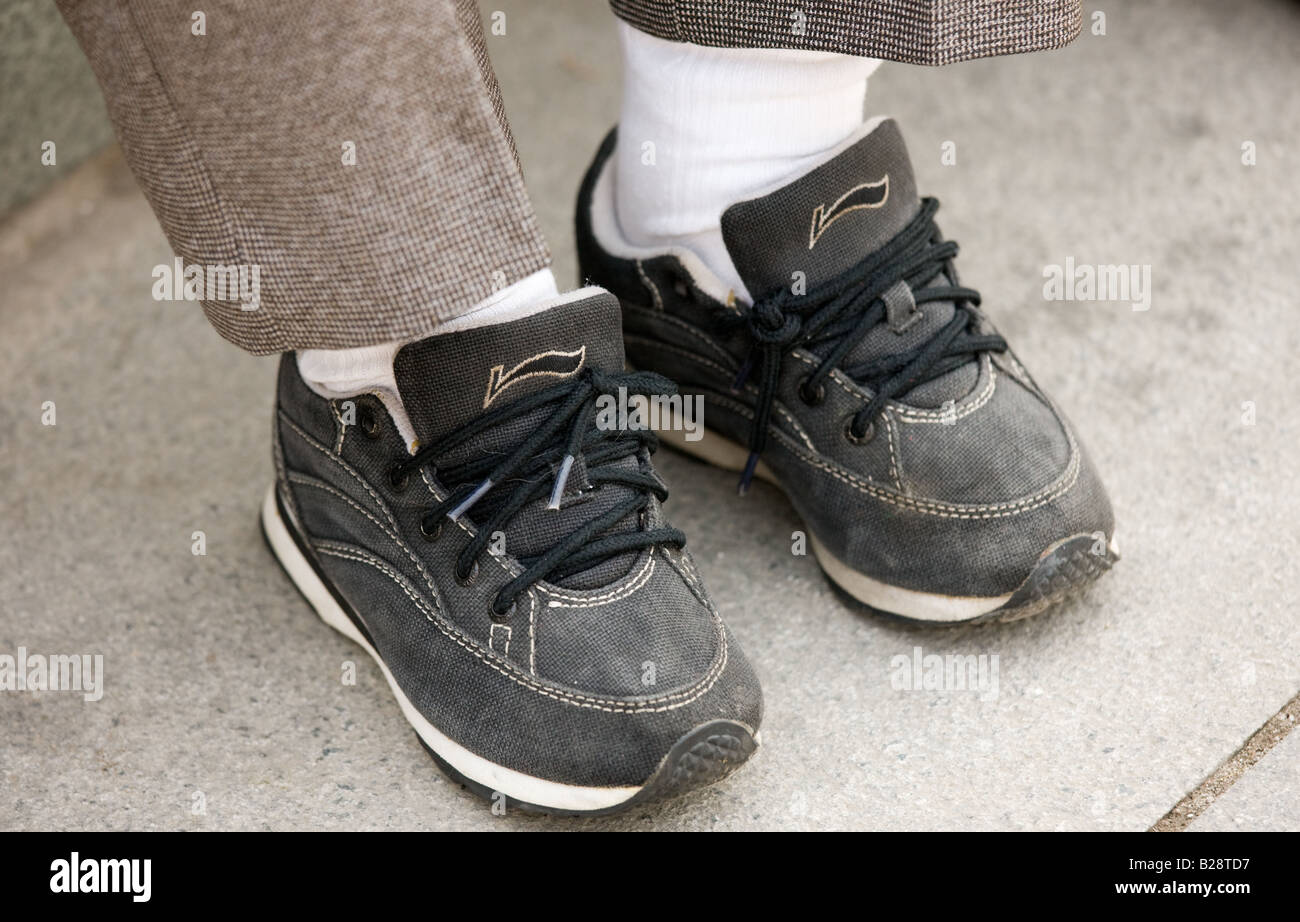 Elderly woman wears fake Nike trainers her small feet having been  previously bound Xian China Stock Photo - Alamy