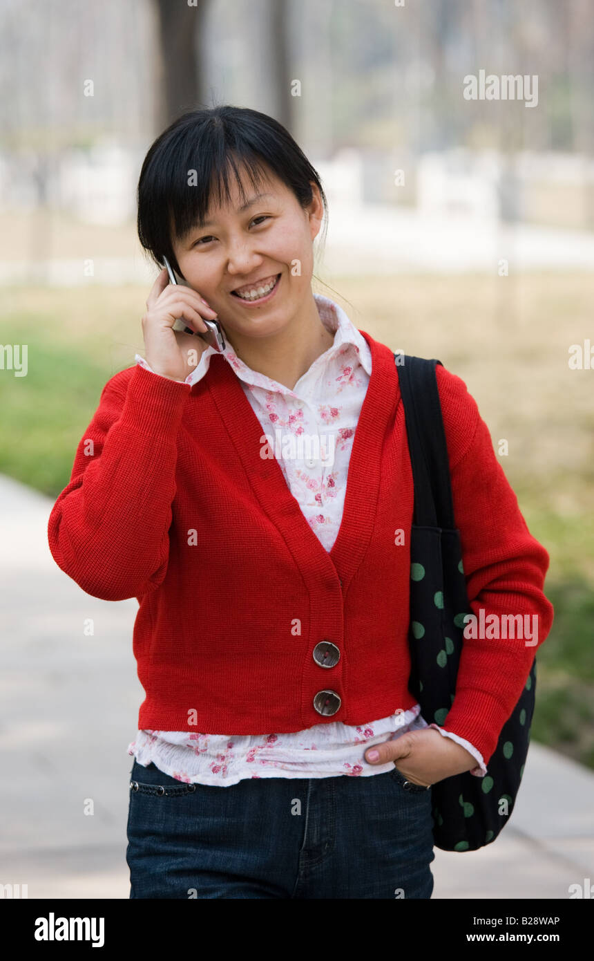Chinese woman chats on mobile phone in Xian China Stock Photo