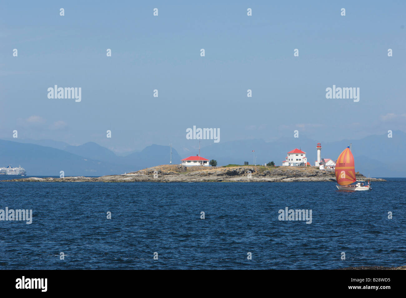 Sailboat passing Entrance Island lighthouse Orlebar Point Gabriola Island British Columbia Canada Stock Photo