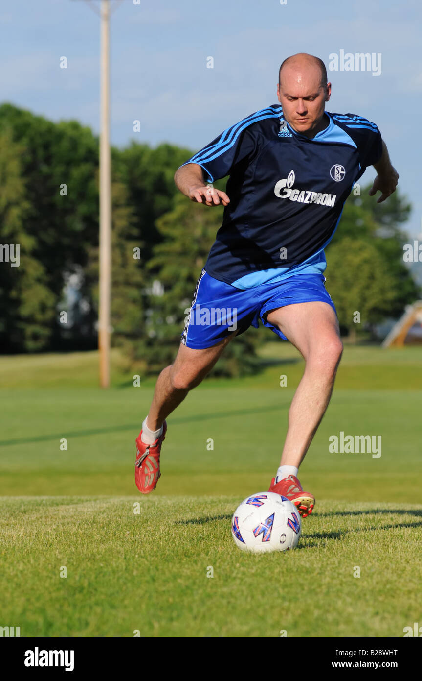 Football player kicking the ball Stock Photo Alamy