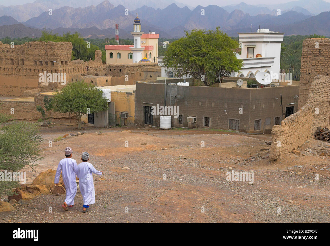 Two Omani boys in white dishdashas walk to prayers in the mountain town of Ar Rustaq Stock Photo