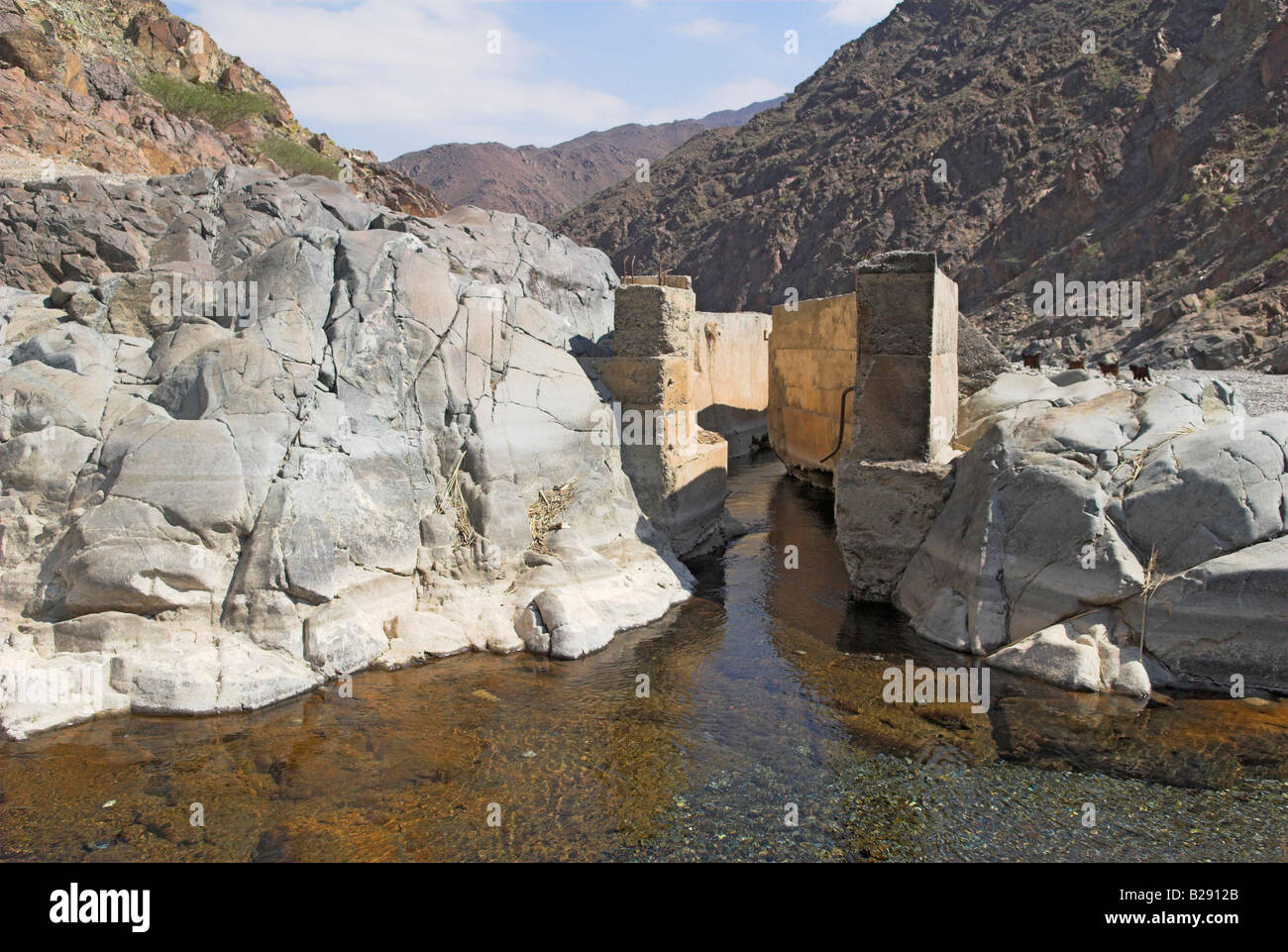 Water runs into a falaj or irrigation channel Wadi al Abyad Oman Stock Photo