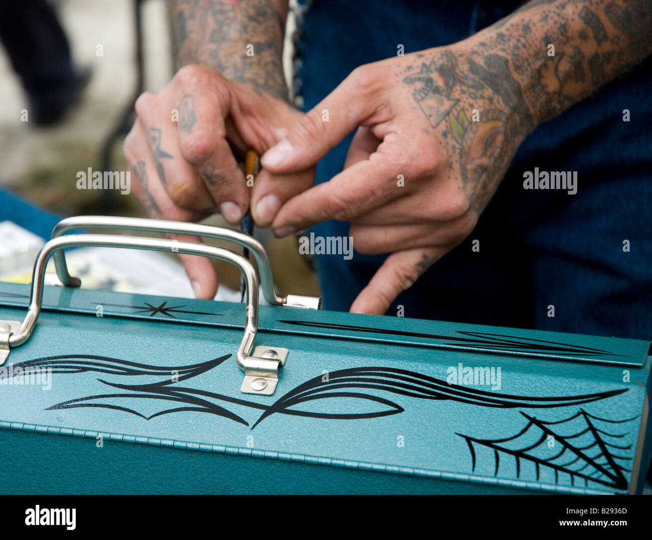 Man painting custom pin stripes on a toolbox Stock Photo