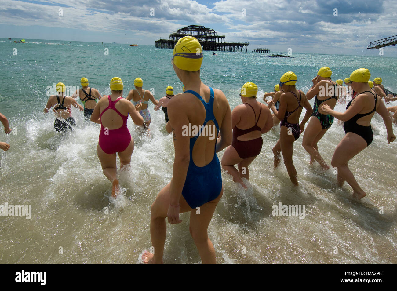 Female swimmers rush into the sea at Brighton for the annual pier to pier race. Stock Photo