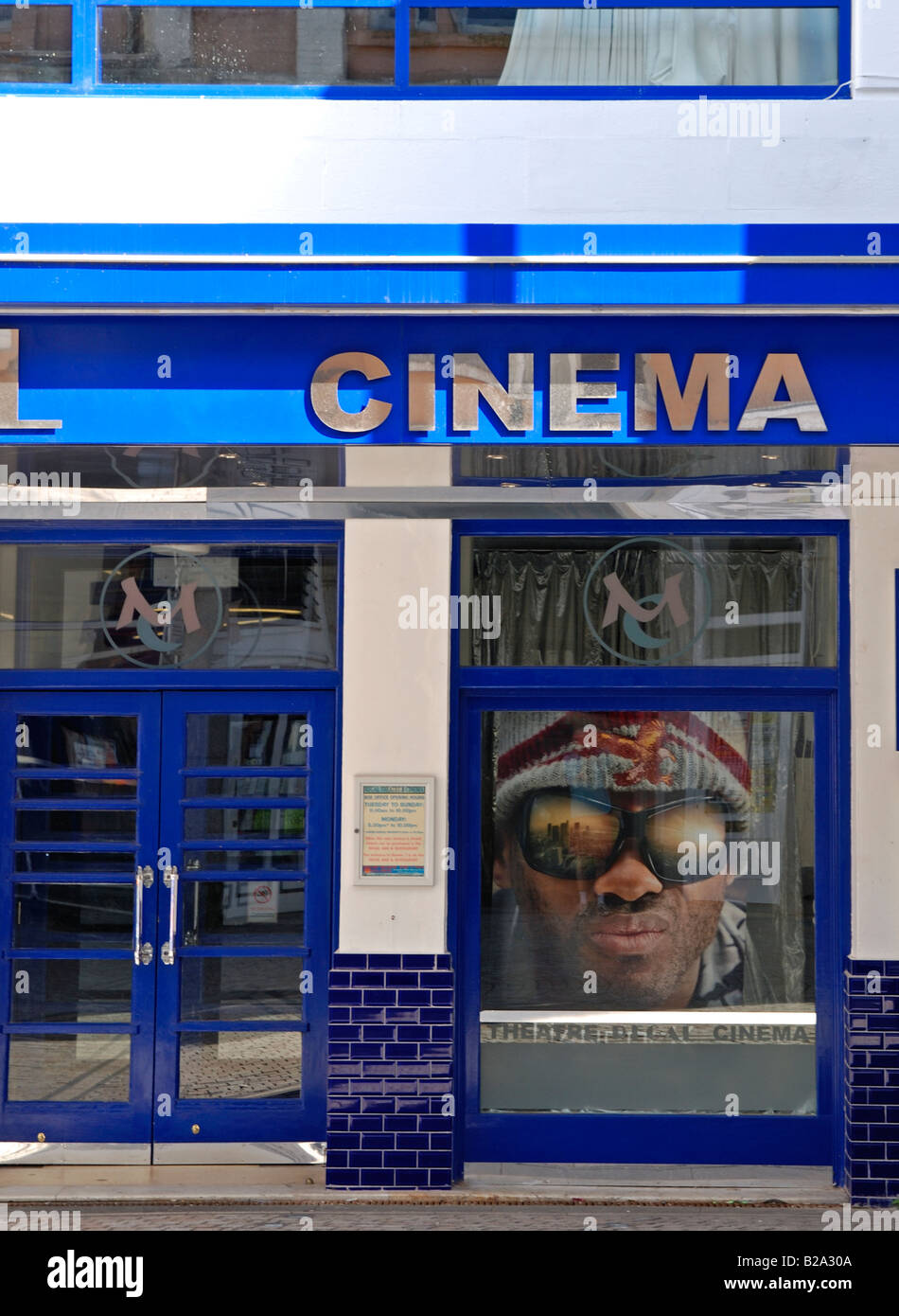 a close up of a cinema entrance door with an advert for the movie 'hancock' in the window Stock Photo