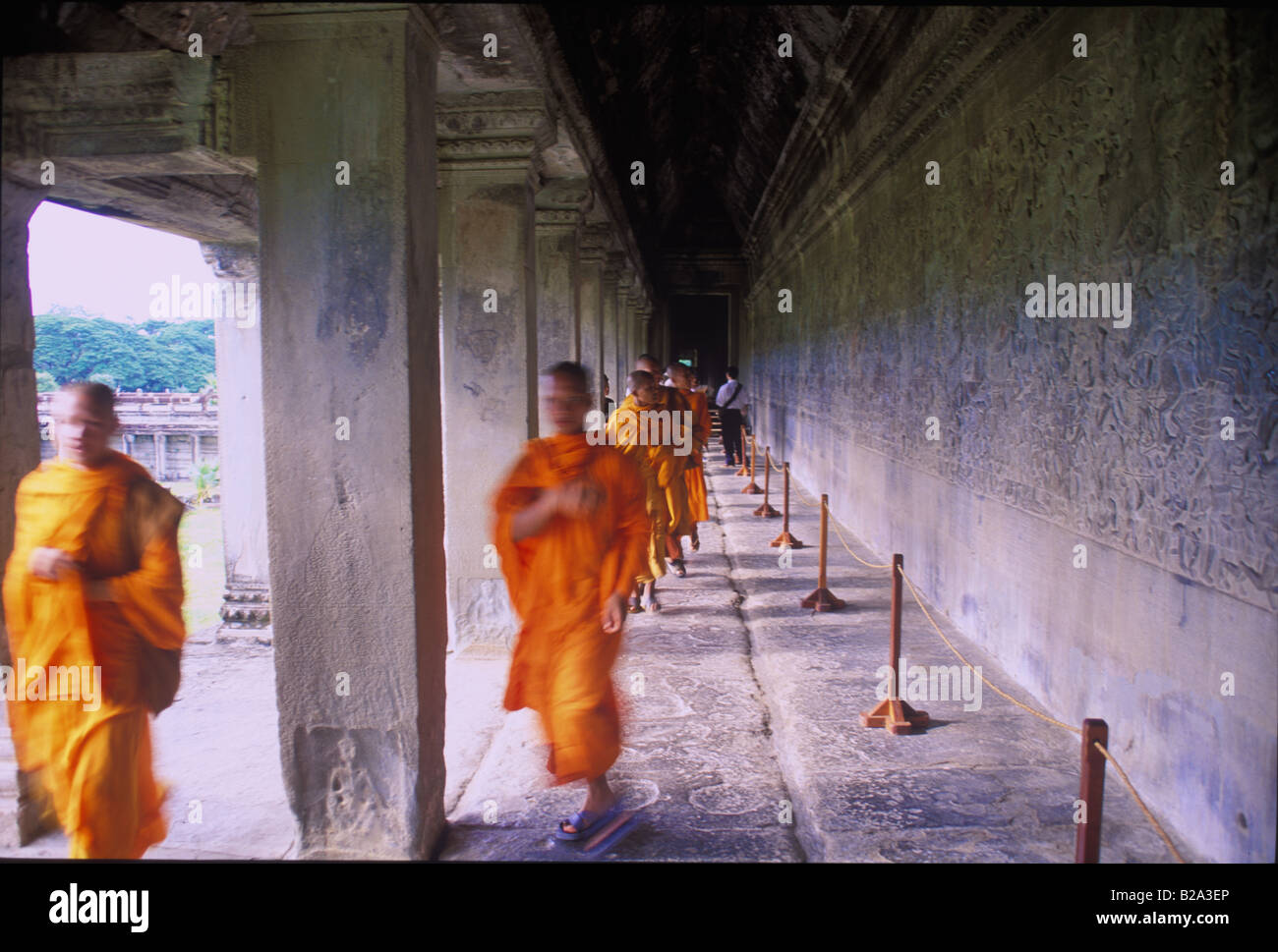 Monks run by wall scripts at Angkor Wat Temple, Siem Reap, Cambodia ...