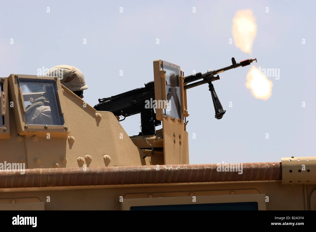 Military Humvee mounted machine gun firing blank rounds during demonstration Stock Photo