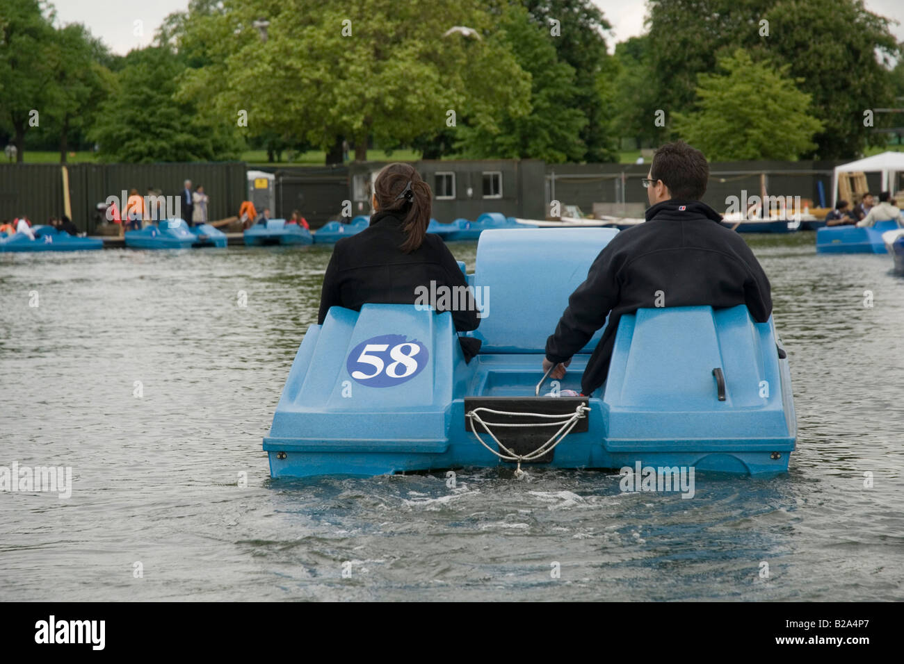 Two persons in paddle boat on serpentine, Hyde Park, London, England