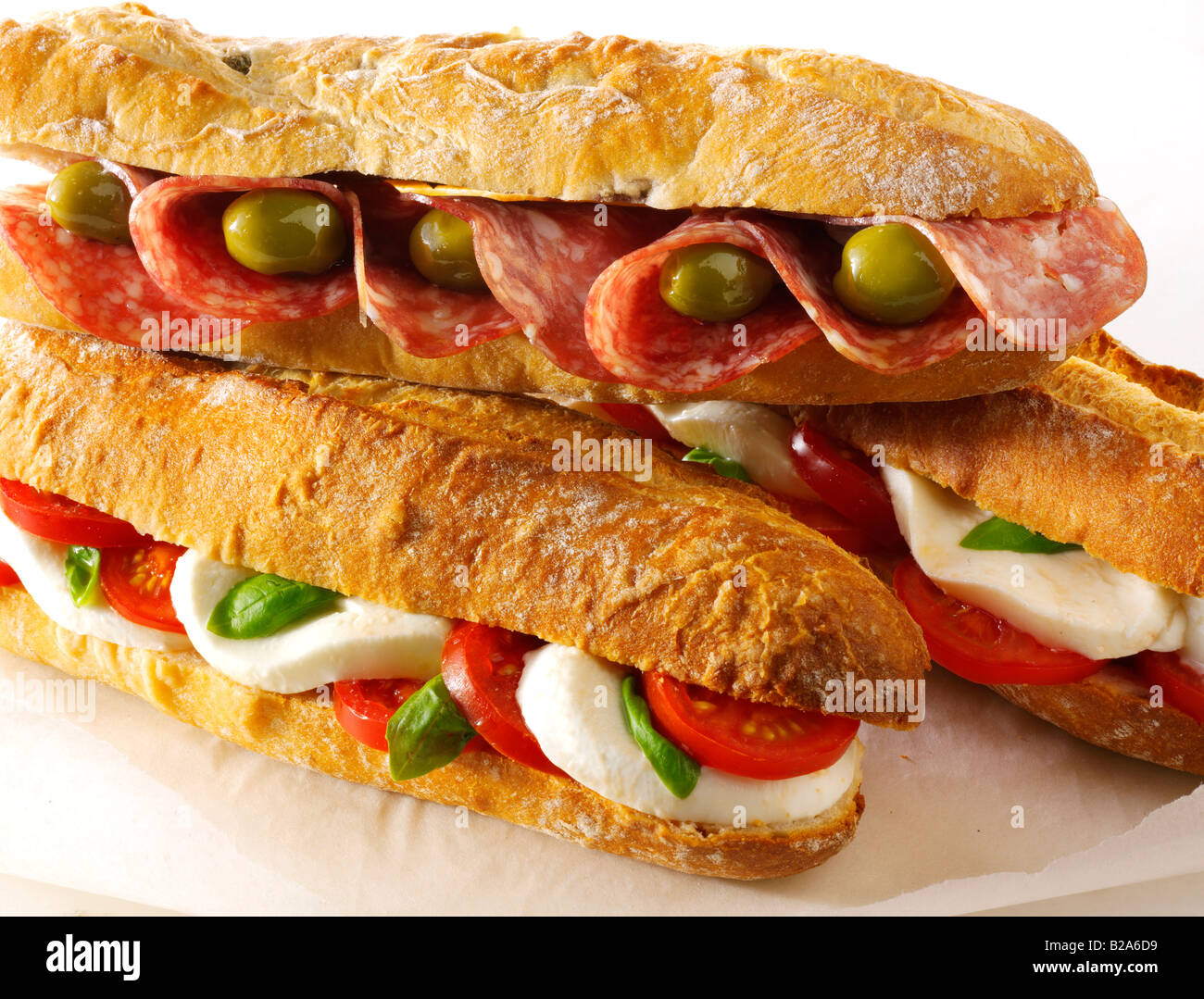 assorted baguette sandwiches against a white background olive and