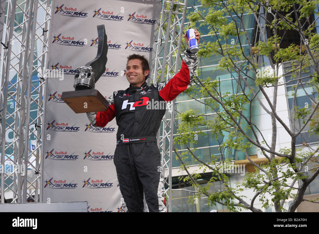 Hannes Arch holds up his 3rd place trophy and a can of Red Bull Energy Drink at the awards ceremony for the Red Bull Air Races. Stock Photo