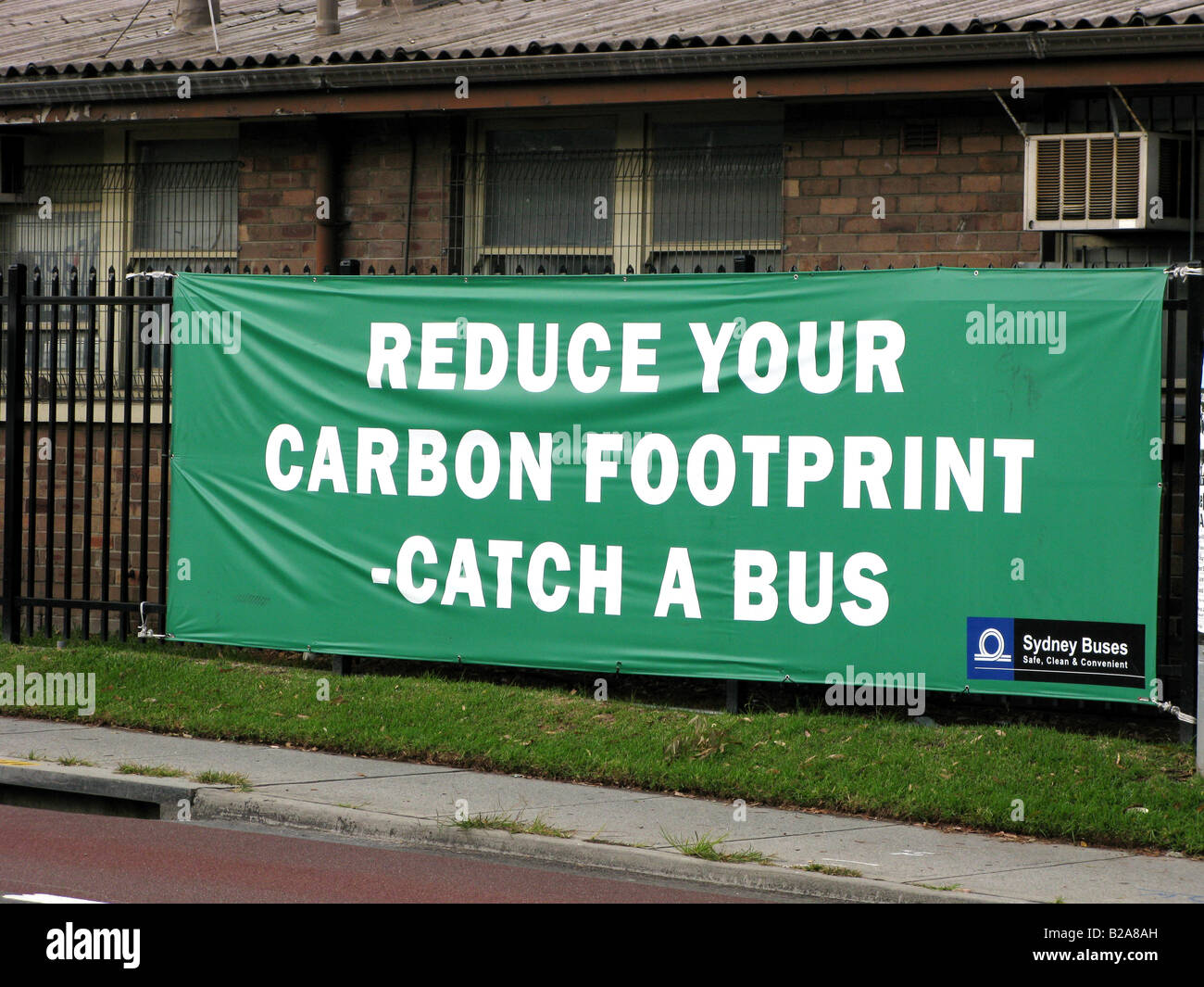 A sign urges commuters to use buses for transport in order to reduce their carbon footprint Stock Photo