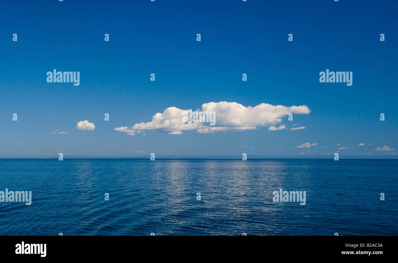 white cloud over calm blue ocean Stock Photo - Alamy