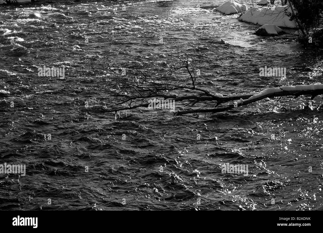 Water flowing down the flooded banks of a river, in Quebec Canada during winter season. Stock Photo