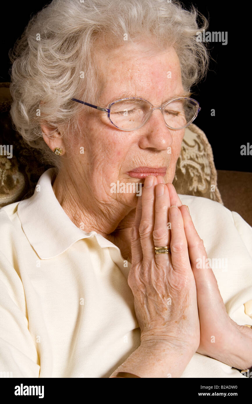 An old woman praying, UK Stock Photo Alamy