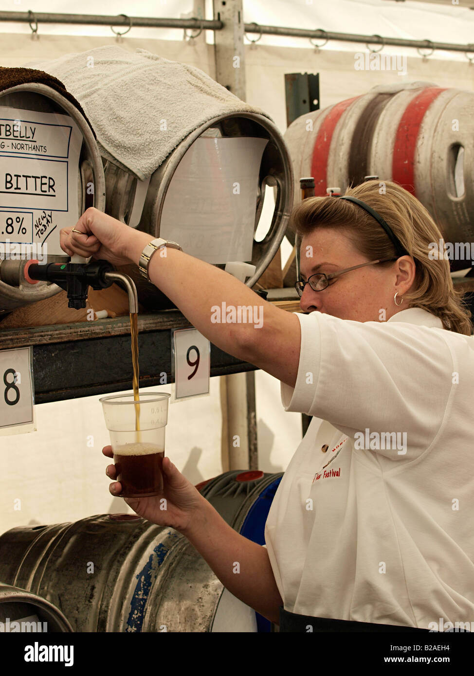 FEMALE BAR STAFF POURING PINT OF REAL ALE BEER FROM RACKED BARREL AT BEER FESTIVAL AT SHERINGHAM NORTH NORFOLK ENGLAND UK Stock Photo