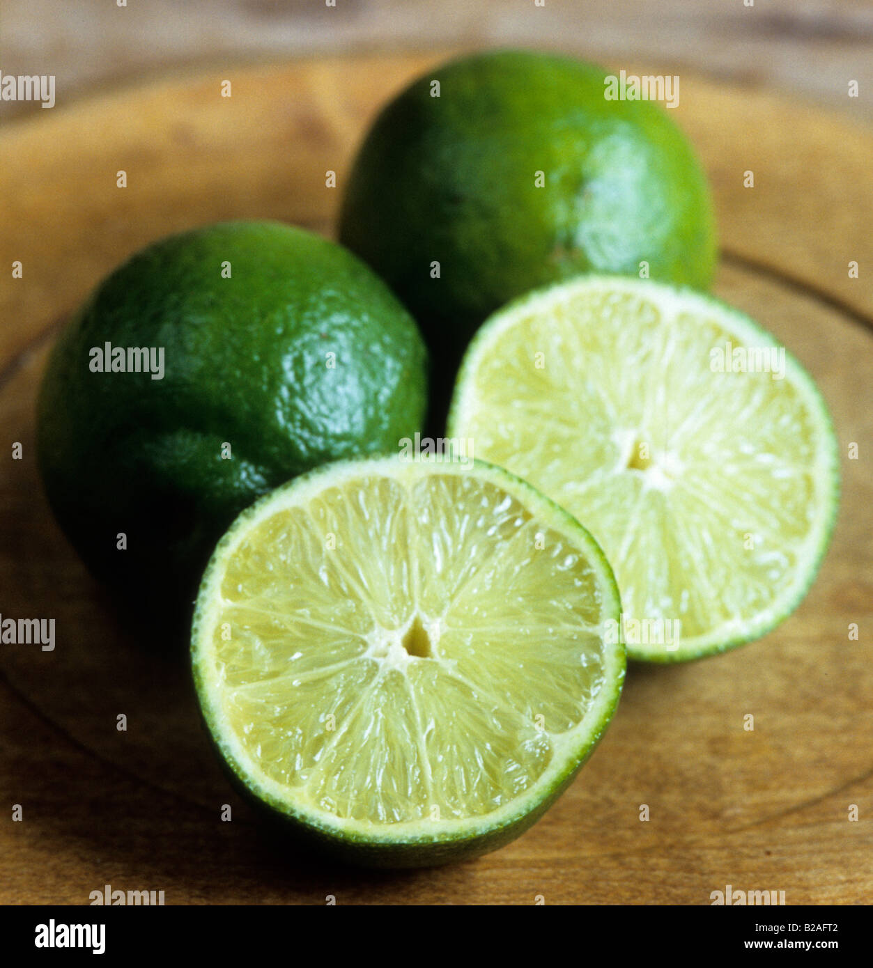 limes cut in half on wooden kitchen board Stock Photo Alamy