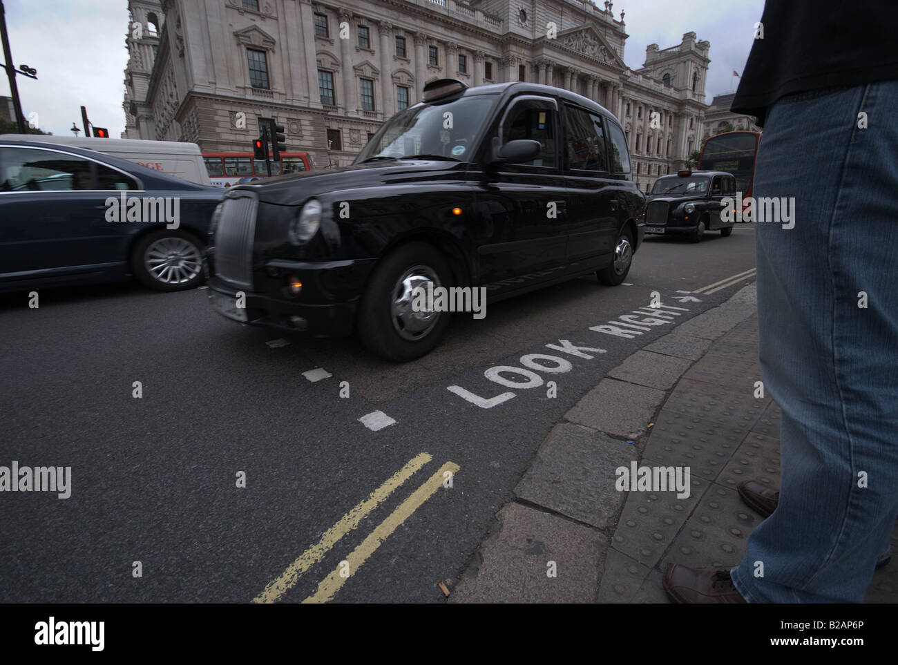 A black taxi cab driving past a pedestrian crossing. Stock Photo