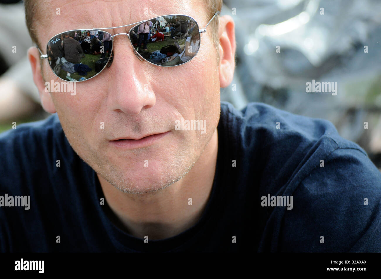 Royalty free photograph of man wearing shade sunglasses and looking at the camera at a music festival in London UK Stock Photo