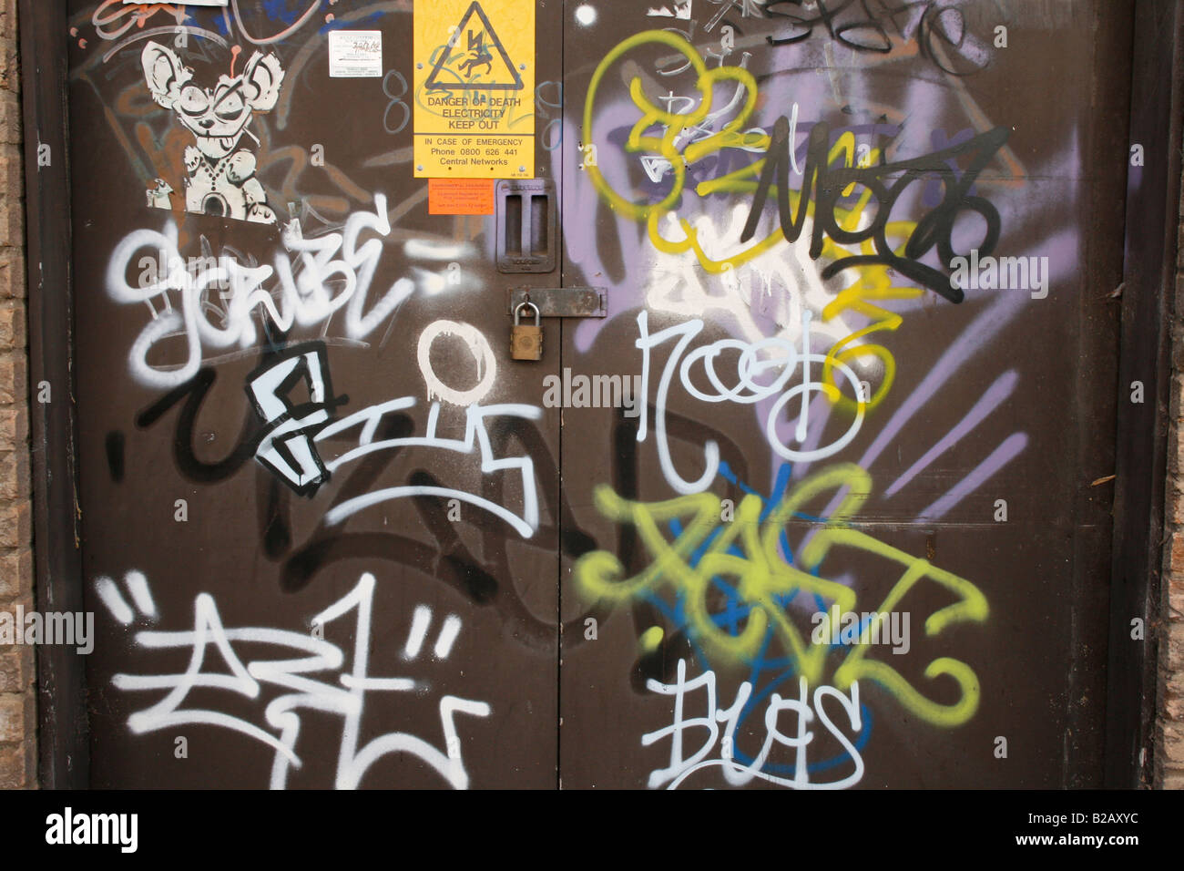 A brown door covered in graffiti.   ( nb : This graffiti has been painted over since the photo was taken. ) Stock Photo