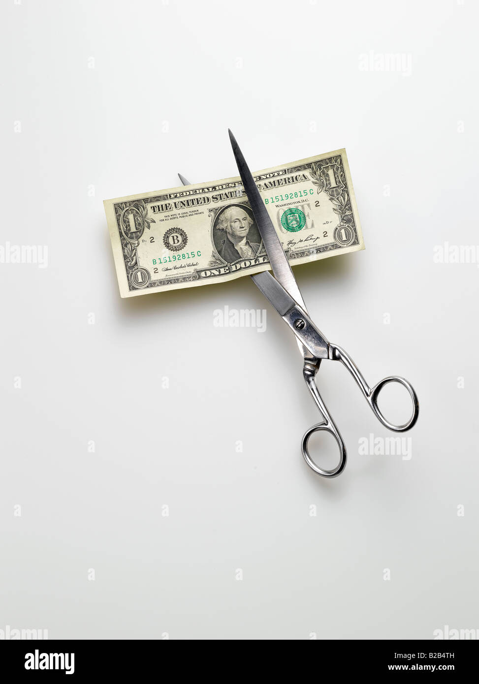 scissors cutting American one dollar bill money on white background