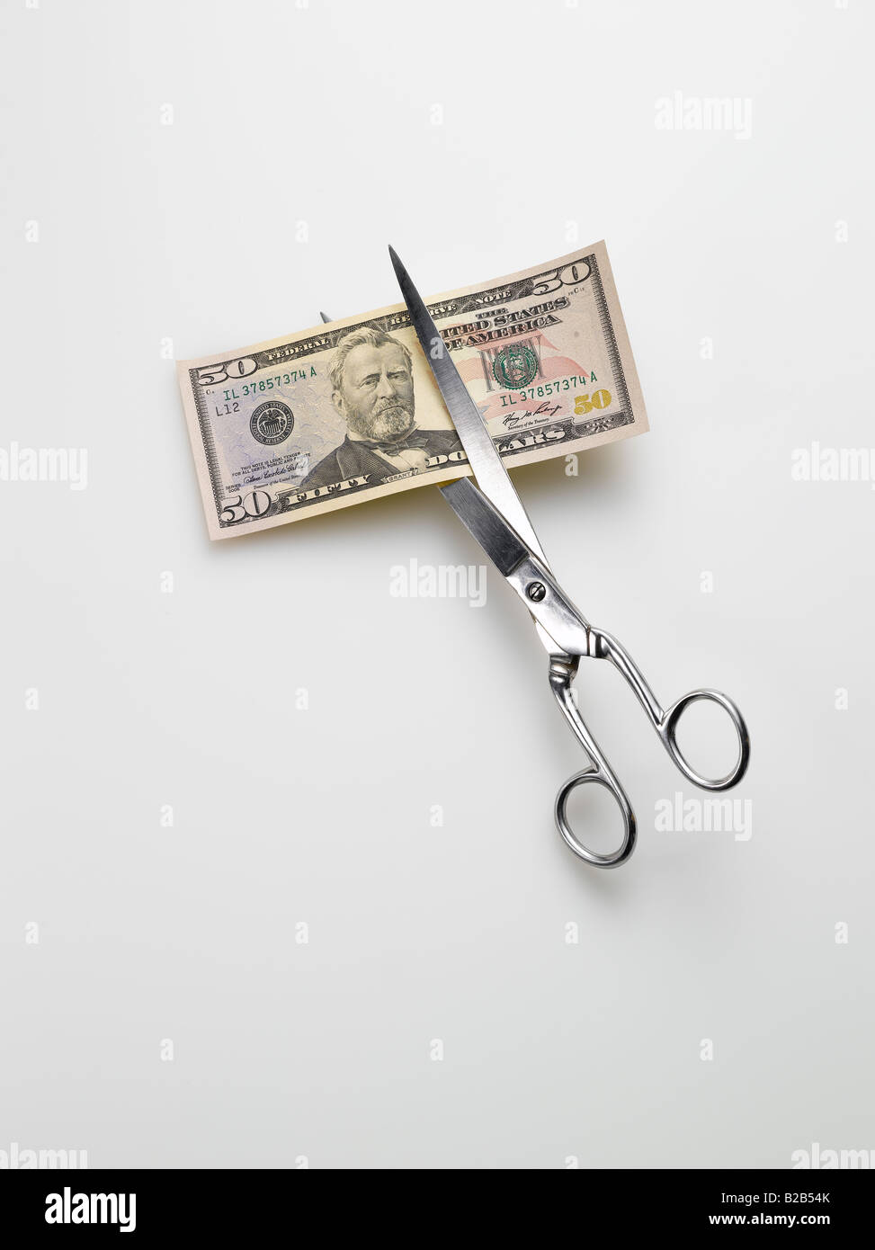 scissors cutting American 5 five dollar bill money on white background Stock Photo