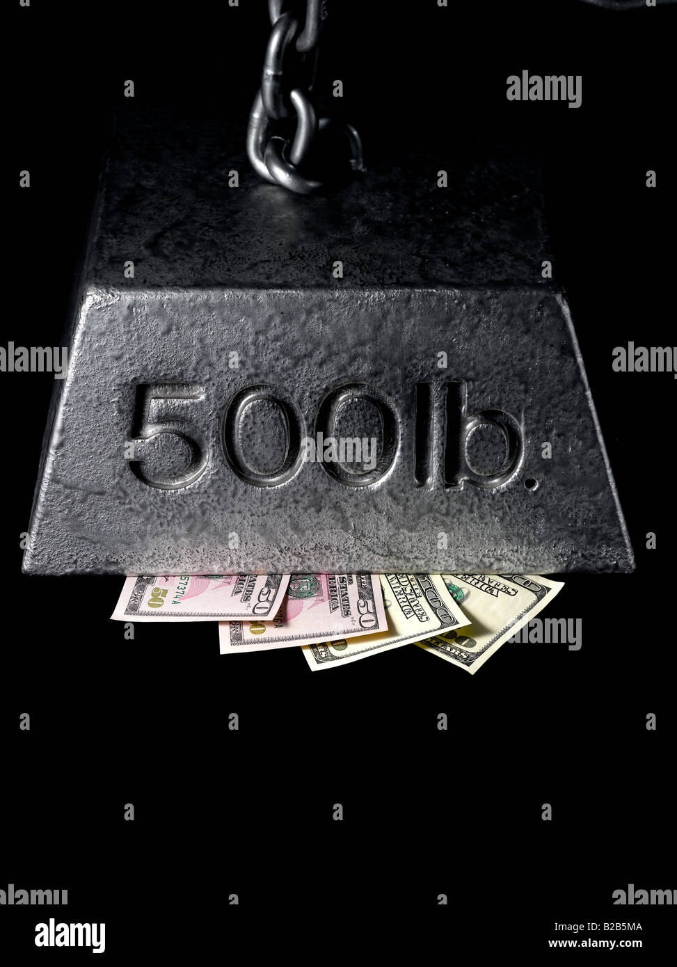 money pressured and squeezed under financial weight Stock Photo