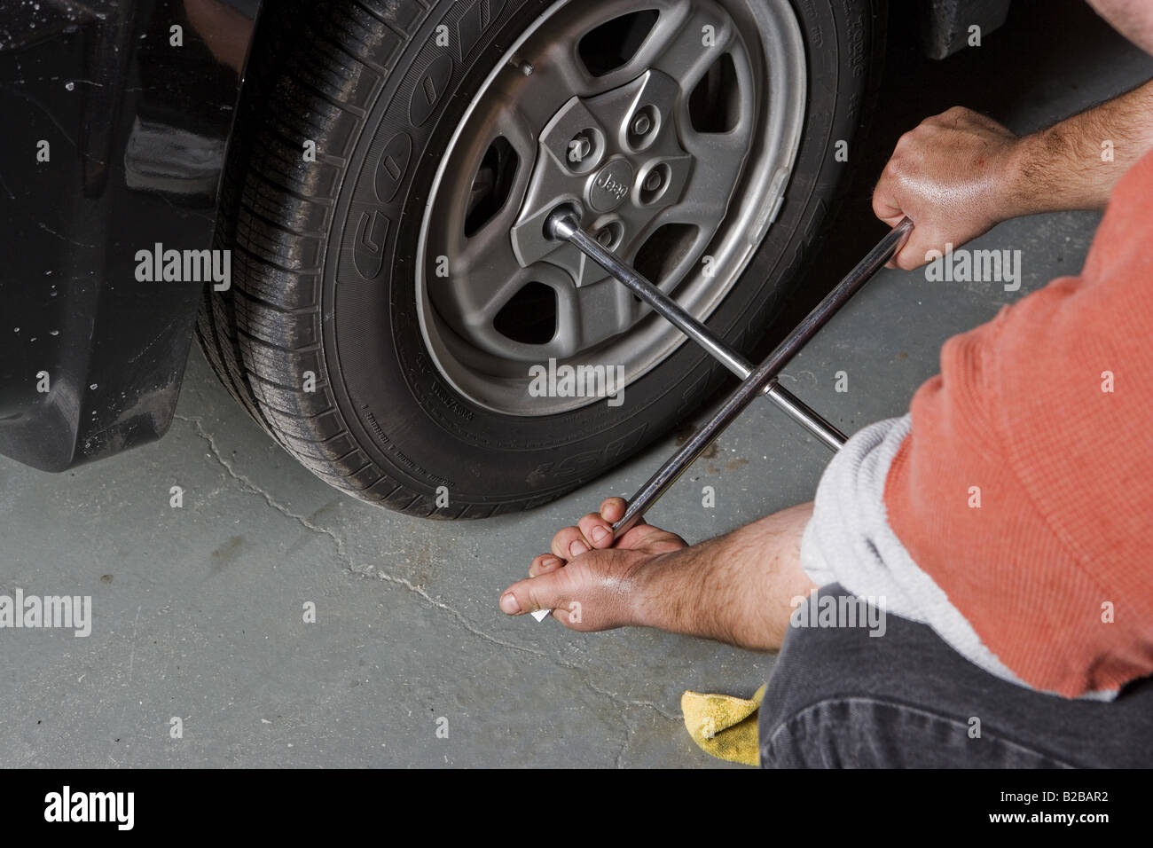 Auto mechanic working on wheel with tire iron Stock Photo Alamy