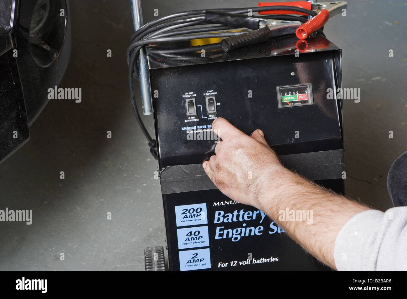 Auto mechanic with battery starter Stock Photo Alamy