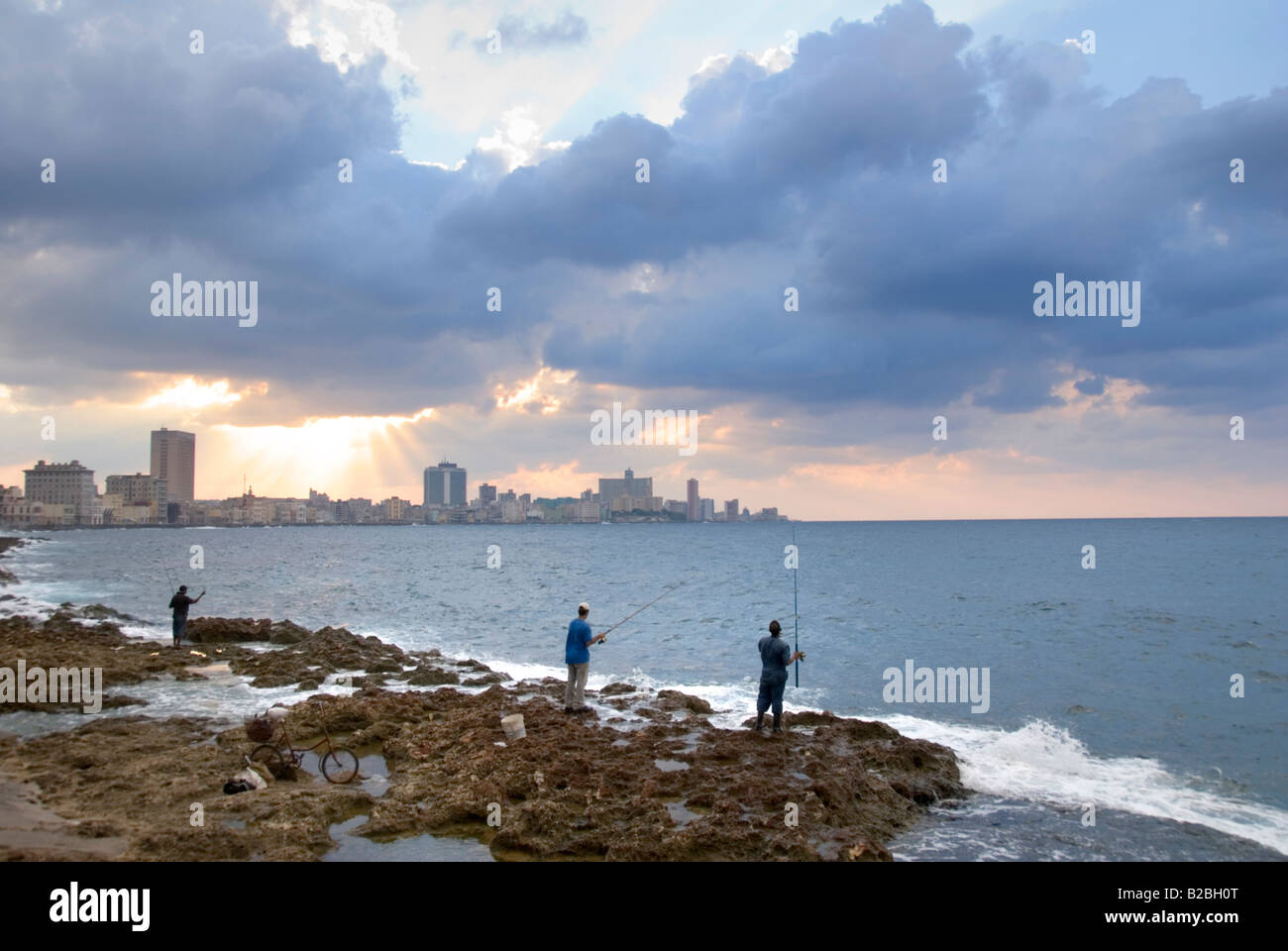 People fishing from El Malecon with view across the bay towards Vedado Havana Cuba Stock Photo
