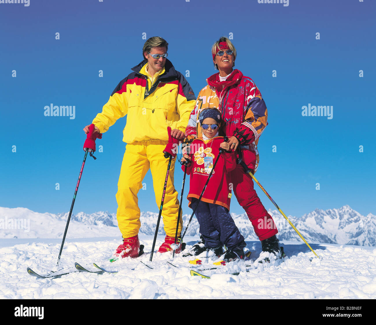 Family relaxing in the snow Stock Photo - Alamy